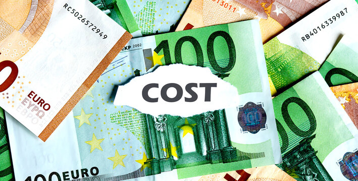 Focus on the word COST , on piece of torn white paper with EUROS currency as a background.