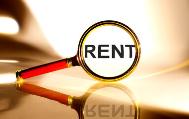 RENT concept. Magnifier glass with text on white background in sunlight.