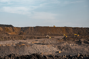 Concept open pit mine industry. Metaphor giraffes excavator moving end of working day