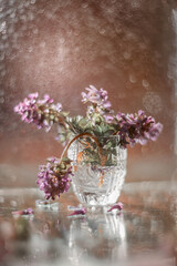 Small bouquet of spring Corydalis flowers in glass, photo taken on manual art lens