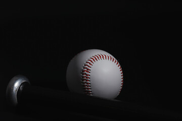 American traditional sports game. Baseball. Concept. Baseball ball and bats on a black table.