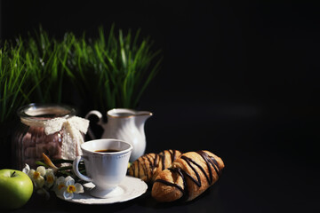 French breakfast on the table. Coffee croissant with chocolate and a decanter with cream. Fresh...