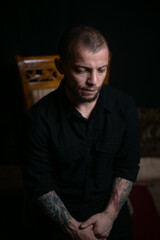 Obraz premium sad guy sitting on black background