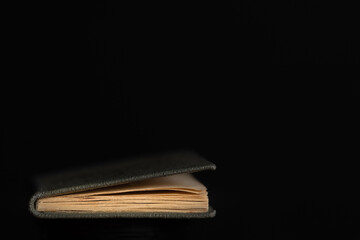 Single old book edge with Gray paper cover, isolated on bleck background