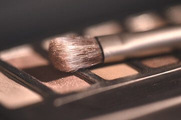 Make up brush on eye shadow palette closeup. Selective focus.