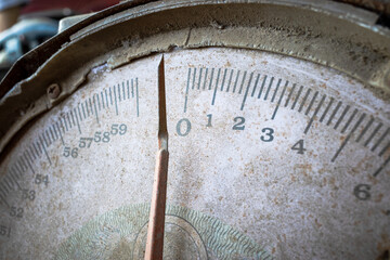A rusty old metal analog trade weight scale used in the market. Close-up. Selective focus.