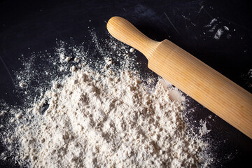 detail of wooden roller to knead the wheat flour for the preparation of pizza