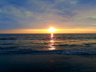 Fototapeta premium sunset over the sea, sunset on the beach, wave on the beach, beautiful sunset view in the Indian Ocean, sunset view in the goa,