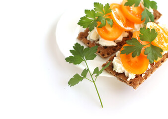 Light Breakfast, healthy food. Crusty bread with soft cottage cheese, tomatoes and parsley.The sandwich is on a white plate, isolated on a white background