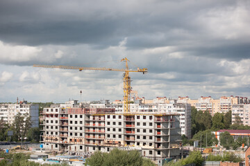 Obraz premium Construction crane on construction site in city on cloudy sky background