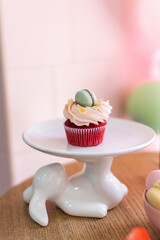 Sweet cupcakes for party. Fresh cupcakes decorated with cream cheese, blueberry and strawberry on modern concrete background. Sweet baked pastry. Easter cupcakes with fruit.