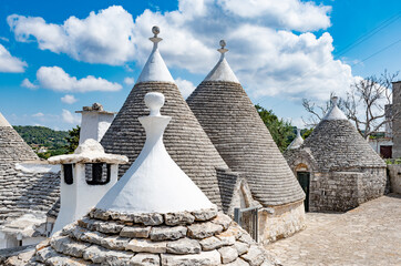 Fototapeta na wymiar Group of beautiful Trulli, traditional Apulian dry stone hut old houses with a conical roof in Itria Valley, Puglia, Italy