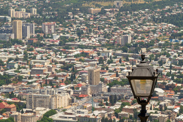 View from the Mtsminda Mountain to a single street lantern against the background of the central districts of Tbilisi