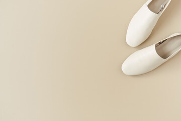 Fashion collage with women's white leather slippers on neutral beige. Flat lay, top view lifestyle concept.