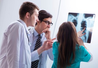 Three doctors discussing scan results of x-ray image