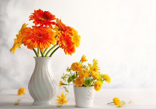 Beautiful Bouquet Of Red And Yellow Flowers In White Vase On Wooden Table, Front View. Autumn Still Life With Flowers.