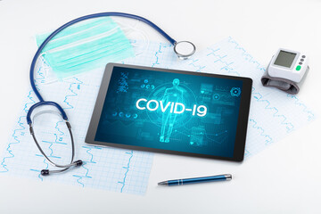 Tablet pc and doctor tools with COVID-19 inscription, coronavirus concept