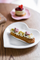Traditional French dessert eclair on a heart-shaped plate.
