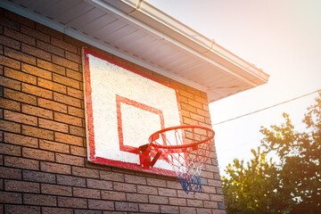 basketball hoop on the house. sunset, sunlight. outdoor sports. healthy lifestyle. Brick wall