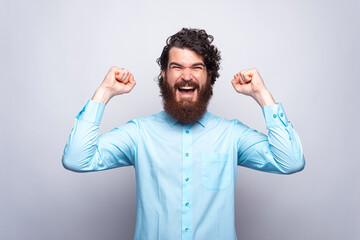Fototapeta premium Portrait of amazed and happy man in blue shirt celebrating victory. GOAL