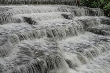 White Water flowing over weir low-level view at long exposure for blurred water effects and textures 