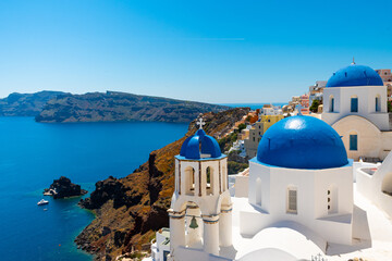 Fototapeta na wymiar Iconic View of churches with blue rooftops in Santorini, Greece, in the town of Oia. 