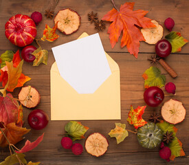 Autumn floral composition with pumpkins and empty blank card in paper envelope.