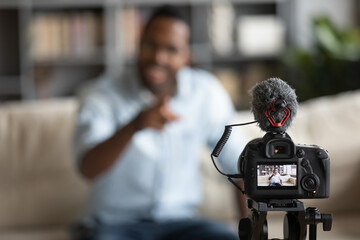 Close up African American blogger using digital camera, recording vlog, young man creating content...