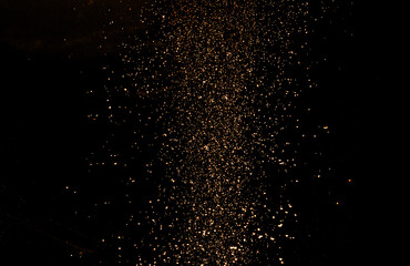 Gold dust (shavings, aerosol) on a black background