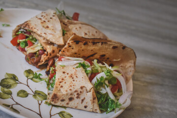 Tortilla wrap sandwiches with mexican beans and vegetables in dish