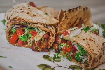 Tortilla wrap sandwiches with mexican beans and vegetables in dish