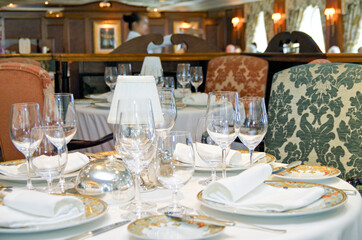 Formal and elegant table setting in dining room or restaurant onboard luxury cruiseship or cruise...