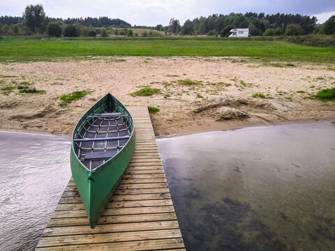 Kanadier auf steg am Strand mit Wohnmobil im Hintergrund