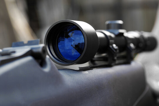 closeup of telescopic sight mounted on rifle for sniper shooting