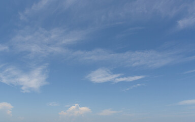 Naklejka na ściany i meble A background image with clouds on a blue sky.