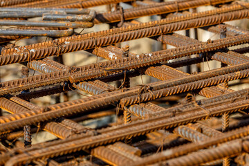 steel rebar for reinforcement concrete at construction site with house under construction background,Industrial background.Rusty rebar for concrete pouring.