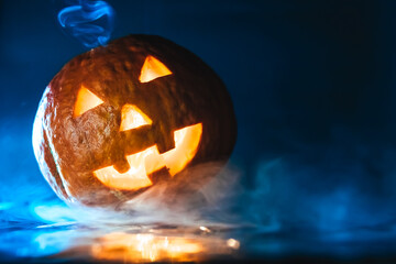 glowing pumpkin in smoke on a dark background. halloween concept. jack-o-lantern. copy space.