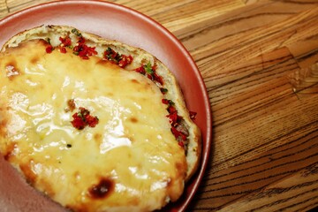 The waiter's hands in black gloves hold two traditional khachapuri with cheese and an egg