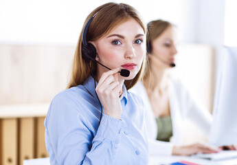Portrait of call center operator at work. Group of people in a headset ready to help customers. Business concept