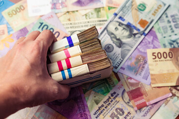 men's hand holds a wad of money