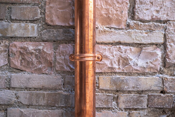 old brick wall with a new copper downspout