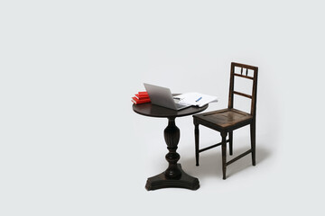 Fototapeta premium Empty table and chair with laptop computer books and paper notes. Distant learning or remote work from home. Isolated on white background.