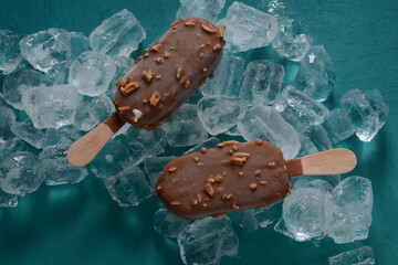 Popsicle chocolate ice cream with almonds on ice cubes background