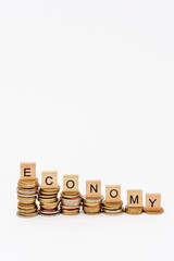 Lettres en bois posées sur des piles de pièces de monnaies de hauteurs décroissantes et...