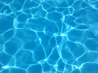 Blue water of a swimming pool in summer with reflections of sunlight