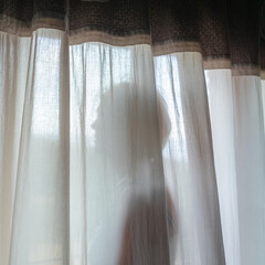 Woman in front of a window with curtains
