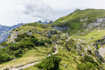 Fototapeta premium The steep path leading to the majestic Schaefler peak in the Alpstein mountain range around the Aescher cliff in Appenzell, Switzerland