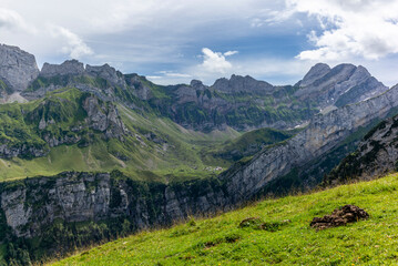 The Meglisalp village in Appenzell, Switzerland sitting betweeen the tall peaks of the Alpstein range in the Swiss Alps