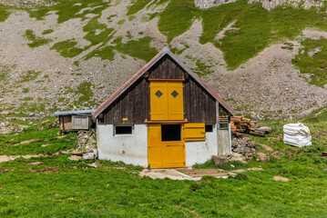 Old log stable on the alpine meadows covered in green grass in the Appenzell canton of Switzerland