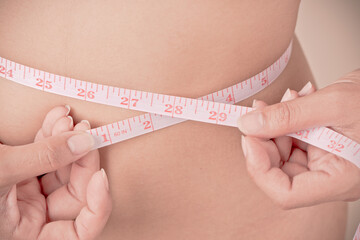 women Slim waist with a tape measure around it